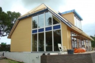 Passief huis met vuren spanten, vloeren en Lariks kozijnen.